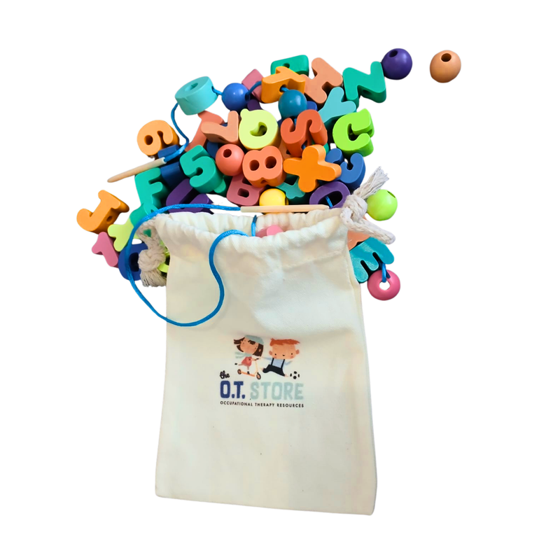 Colourful alphabet and number lacing beads spilling out of a small cream drawstring bag with a blue string on a white background