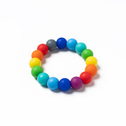 Stretchy bracelet made of large round beads in a rainbow of vibrant colours arranged in a circle on a white background