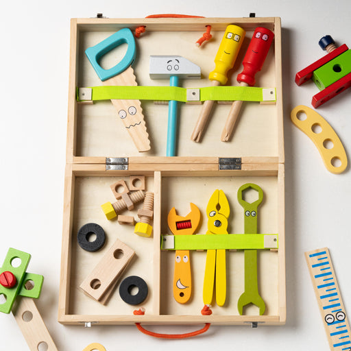 Open wooden carpenter set with colourful painted toy tools, screws, and bolts arranged inside compartments on a white background.